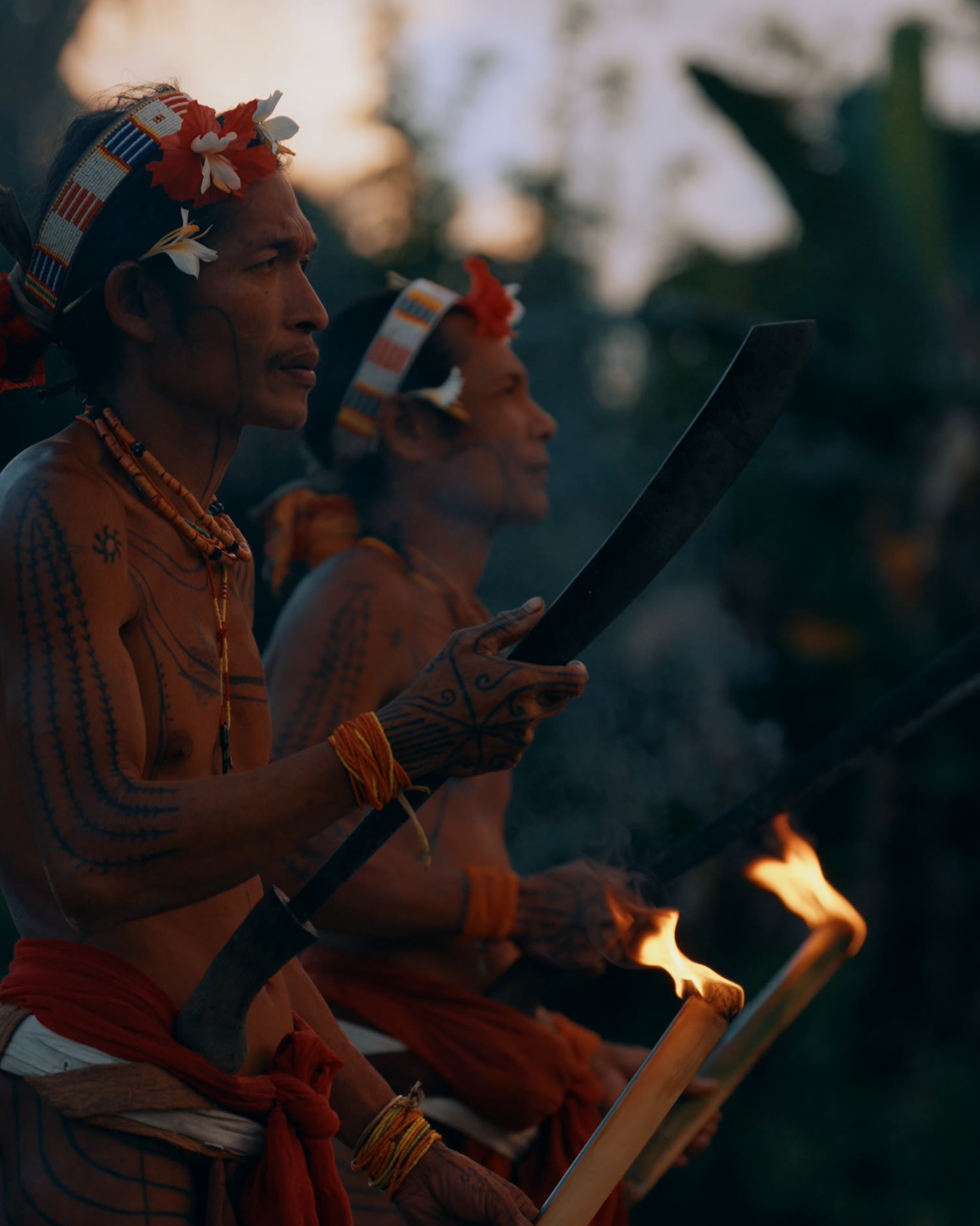 Mentawai men in traditional dress with torches at dusk